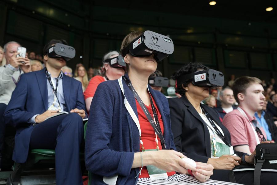 Visually impaired tennis fans, in their seats at Wimbledon, wearing GiveVision headsets powered by Vodafone 5G.