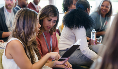 Image of two women sitting next to each other talking